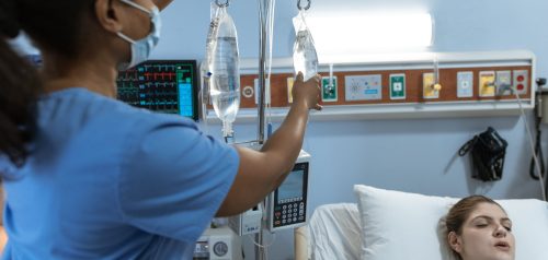 Nurse attending patient with IV infusion