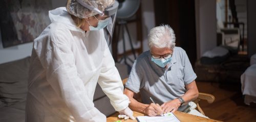 Older patient completing documents with healthcare professional